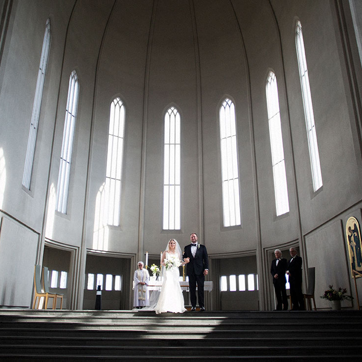 Brúðhjónin standa við altarið í Hallgrímskirkju