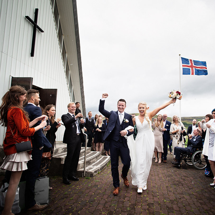 Brúðhjónin koma fagnandi út úr kirkjunni
